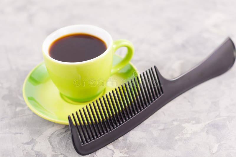 Kies nieuwe plastic kam dichtbij volledige kop van zwarte smakelijke koffie op groene ronde ceramische schotel uit royalty-vrije stock afbeeldingen Kies nieuwe plastic kam dichtbij volledige kop van zwarte smakelijke koffie op groene ronde ceramische schotel uit royalty-vrije stock afbeeldingen