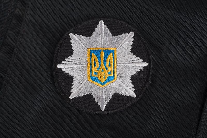 KIEV, DE OEKRAÏNE - NOVEMBER 22, 2016 Flard en kenteken van de Nationale Politie van de Oekraïne op zwarte eenvormige achtergrond royalty-vrije stock fotografie KIEV, DE OEKRAÏNE - NOVEMBER 22, 2016 Flard en kenteken van de Nationale Politie van de Oekraïne op zwarte eenvormige achtergrond royalty-vrije stock fotografie