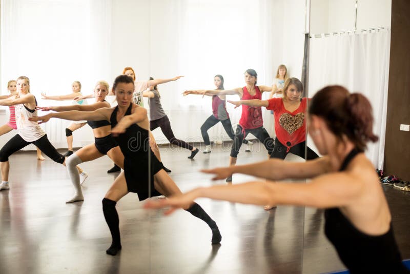 Group portrait of girls with female choreographer doing interest position in the modern dance studio.professional dancer. young girls in a dance lesson in a modern dance school. Group portrait of girls with female choreographer doing interest position in the modern dance studio.professional dancer. young girls in a dance lesson in a modern dance school.