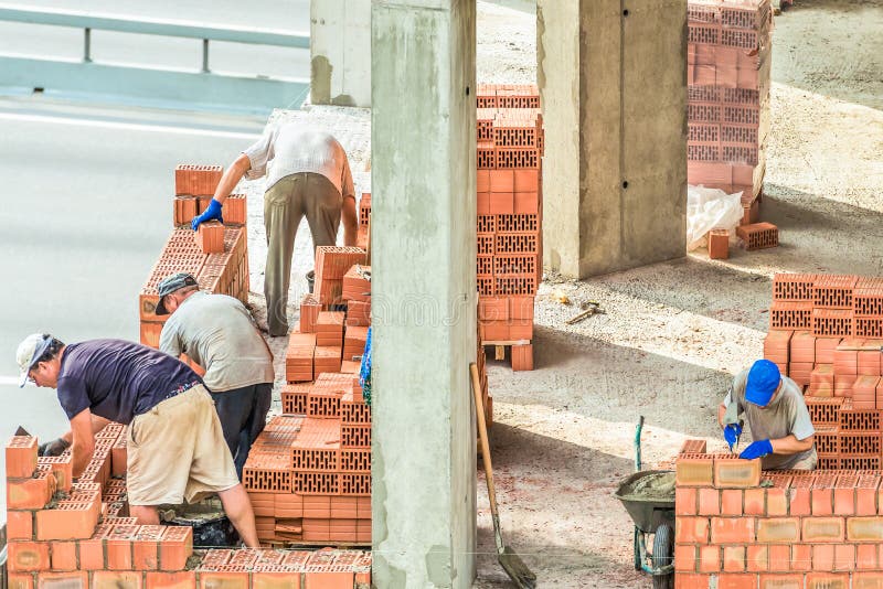 Kiev, Ukraine - July 17, 2018: Workers work at the construction site. Work is under way to lay a wall of red brick.