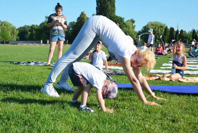 KIEW, UKRAINE - 24. JULI 2019: Kinder Yoga, Kinderyoga, Familienyoga, Mutter und Sohn im Freien lizenzfreies stockfoto KIEW, UKRAINE - 24. JULI 2019: Kinder Yoga, Kinderyoga, Familienyoga, Mutter und Sohn im Freien lizenzfreies stockfoto