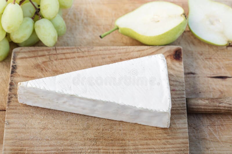 Kil av Brie på lantlig vit träbackeround vit s royaltyfria bilder Kil av Brie på lantlig vit träbackeround vit s royaltyfria bilder