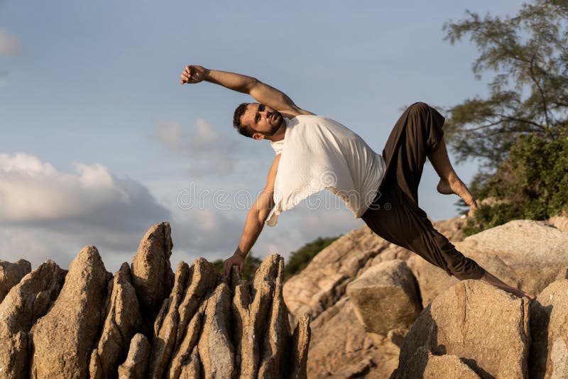 Killen som gör yoga lägger ut på vassa stenar nära stranden i Thailand royaltyfri fotografi