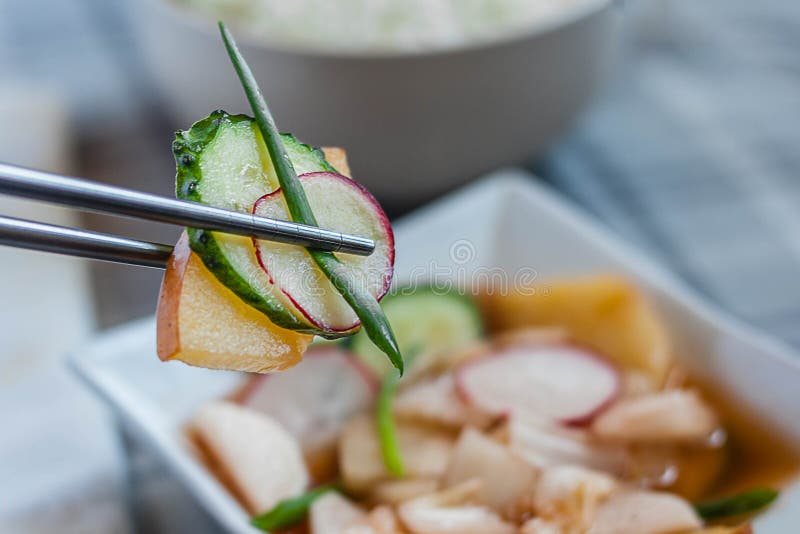 Kimchi Nabak, kimchi φρούτων και λαχανικών, κόκκινο kimchi νερού, banchan, sidedish, κορεατικά τουρσιά με chopsticks μετάλλων και στοκ εικόνα Kimchi Nabak, kimchi φρούτων και λαχανικών, κόκκινο kimchi νερού, banchan, sidedish, κορεατικά τουρσιά με chopsticks μετάλλων και στοκ εικόνα