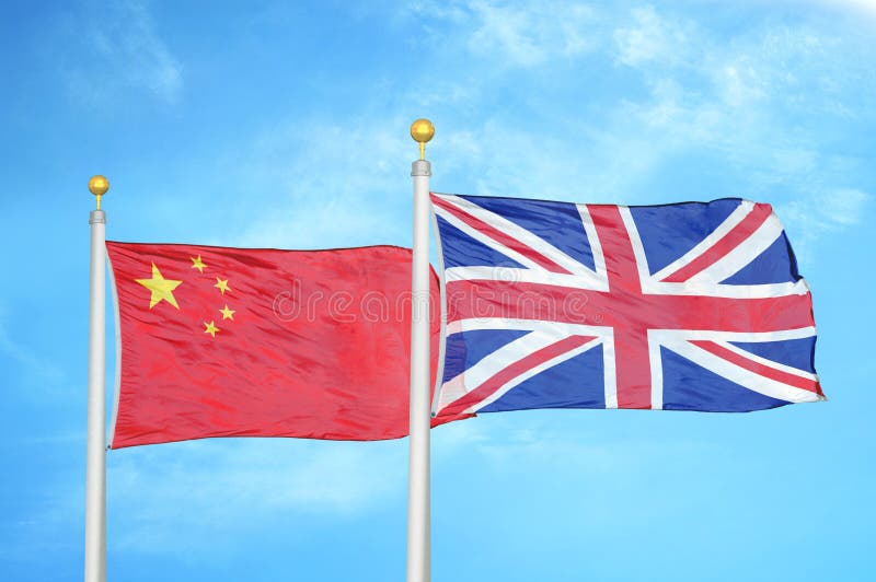 China and United Kingdom two flags on flagpoles and blue cloudy sky background. China and United Kingdom two flags on flagpoles and blue cloudy sky background