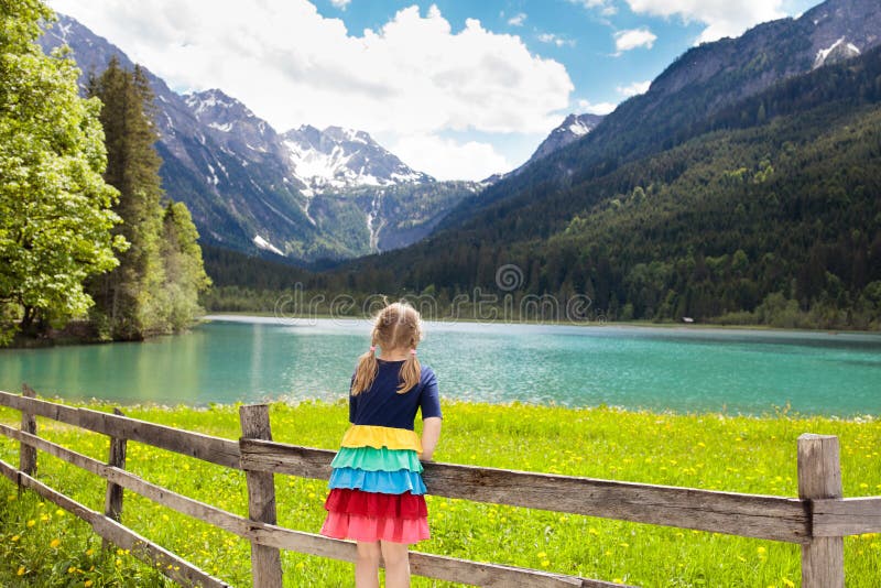 Kind, das auf dem Blumengebiet am Gebirgssee wandert stockfotos Kind, das auf dem Blumengebiet am Gebirgssee wandert stockfotos