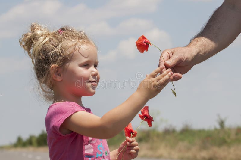 Kid receiving flowers from a man. Kid receiving flowers from a man.