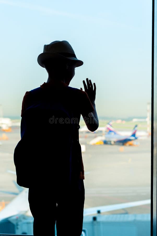 Kind, das das Flugzeug vom Flughafen aus betrachtet stockfotos