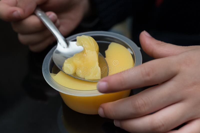 Kind, das Mangoaromapudding isst lizenzfreie stockfotos Kind, das Mangoaromapudding isst lizenzfreie stockfotos