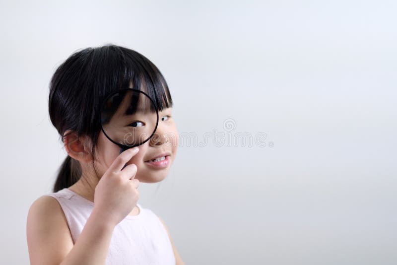 Kind des kleinen Mädchens, das durch eine Lupe auf weißem Hintergrund schaut stockbilder Kind des kleinen Mädchens, das durch eine Lupe auf weißem Hintergrund schaut stockbilder