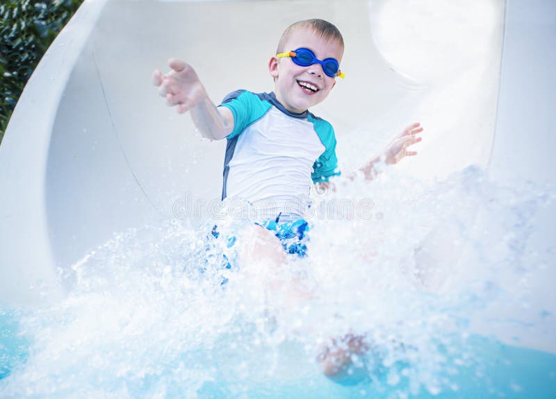 Kind die opgewekt en pret hebben die onderaan een waterslide gaan stock afbeelding Kind die opgewekt en pret hebben die onderaan een waterslide gaan stock afbeelding