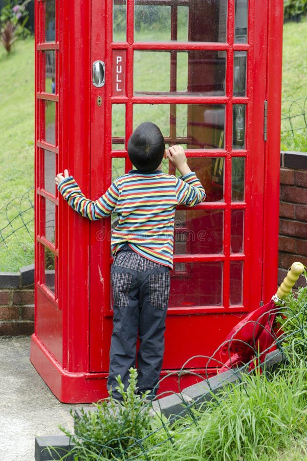 Kind door een Brithish-telefoondoos royalty-vrije stock foto's Kind door een Brithish-telefoondoos royalty-vrije stock foto's