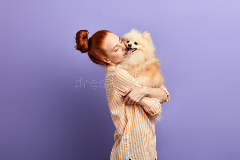 Kind girl is embracing her dog as she hasn`t seen it for a long time