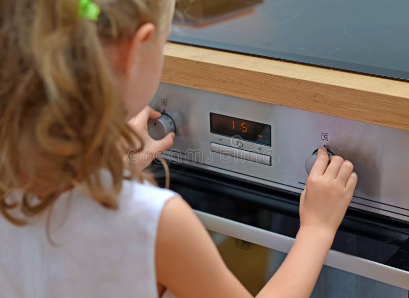 Dangerous situation in the kitchen. Child playing with electric oven. Dangerous situation in the kitchen. Child playing with electric oven.