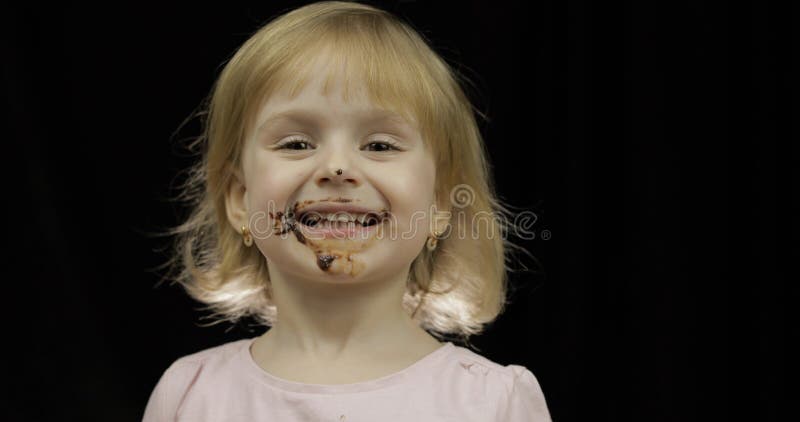 Kind isst geschmolzene Schokolade und Schlagsahne Schmutziges Gesicht lizenzfreie stockfotos Kind isst geschmolzene Schokolade und Schlagsahne Schmutziges Gesicht lizenzfreie stockfotos