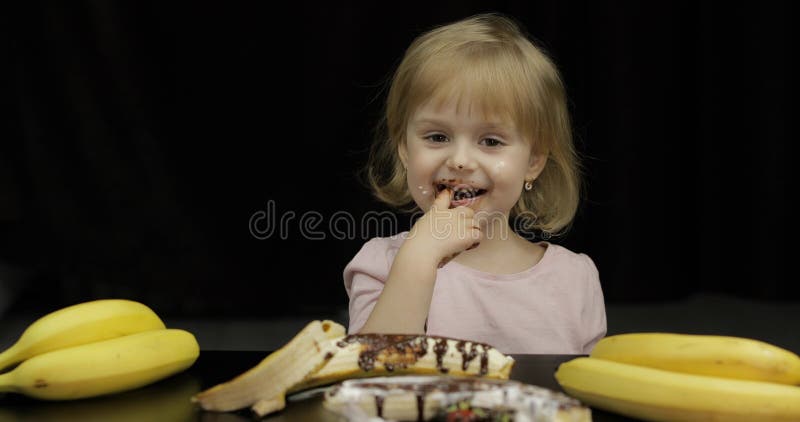 Kind isst geschmolzene Schokolade und Schlagsahne Schmutziges Gesicht stockbild Kind isst geschmolzene Schokolade und Schlagsahne Schmutziges Gesicht stockbild