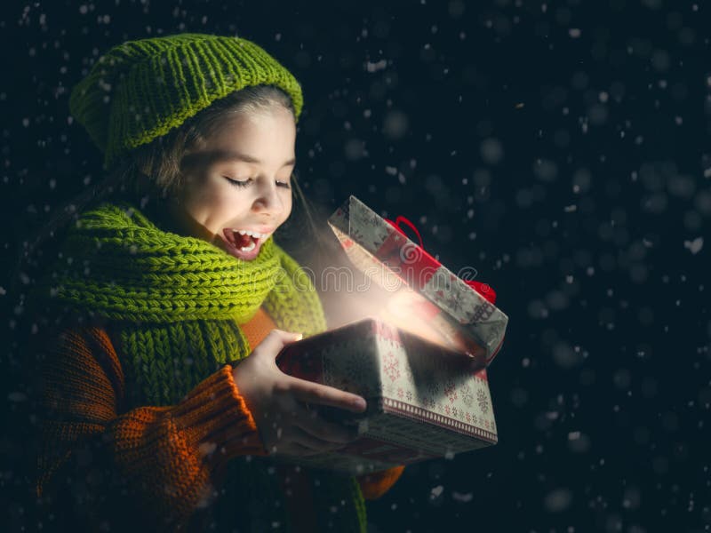 Kind mit Geschenkbox auf dunklem Hintergrund lizenzfreie stockfotos Kind mit Geschenkbox auf dunklem Hintergrund lizenzfreie stockfotos
