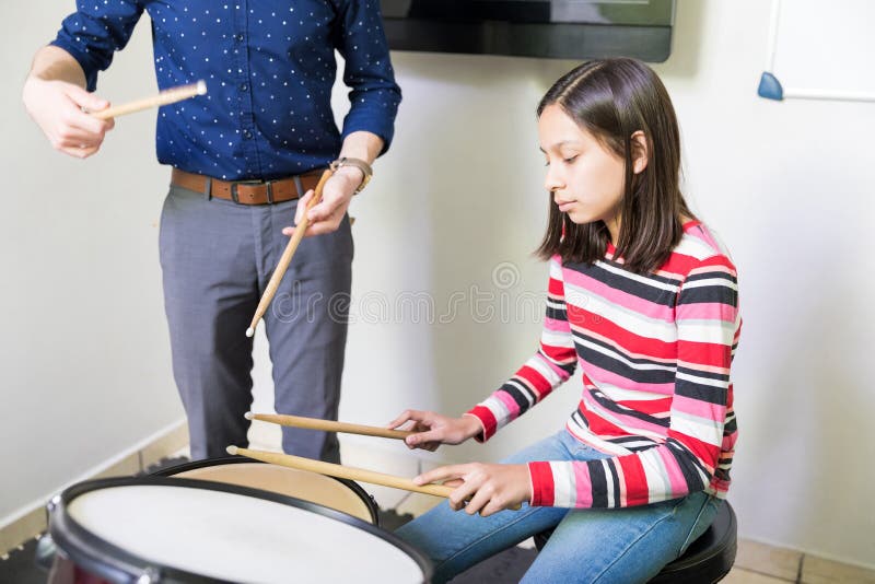 Kind mit Lehrer-Practicing Drum In-Musik-Klasse