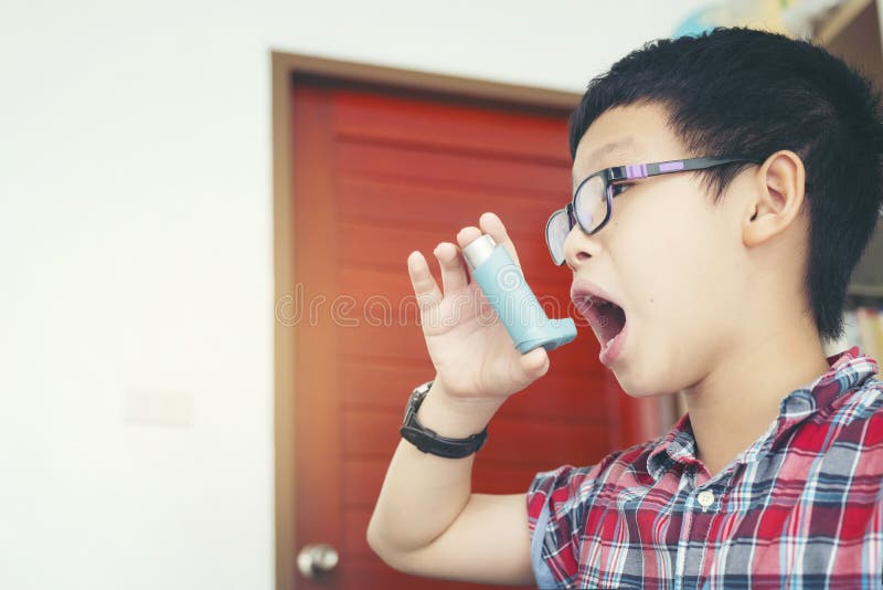 Kind mit Spray, Junge, der zu Hause seinen Asthmapumpeninhalator, alle verwendet stockbild Kind mit Spray, Junge, der zu Hause seinen Asthmapumpeninhalator, alle verwendet stockbild