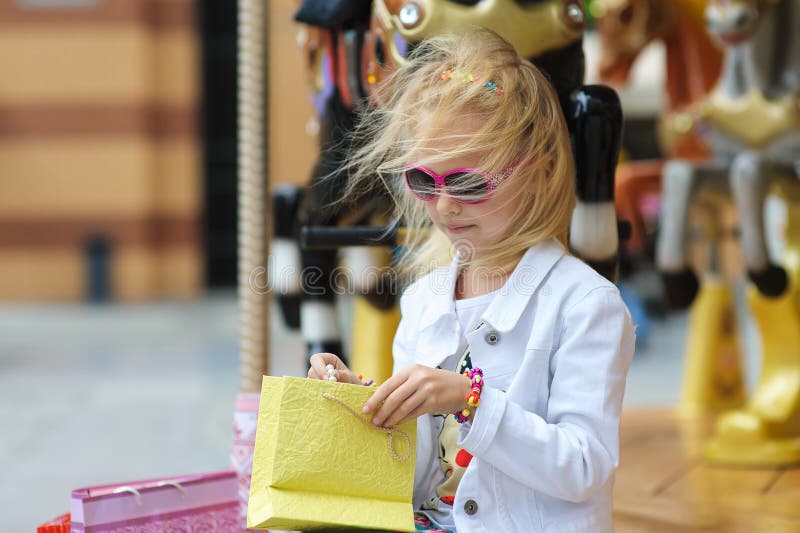 Kind op Carrousel met volledige het winkelen zakken royalty-vrije stock foto's Kind op Carrousel met volledige het winkelen zakken royalty-vrije stock foto's