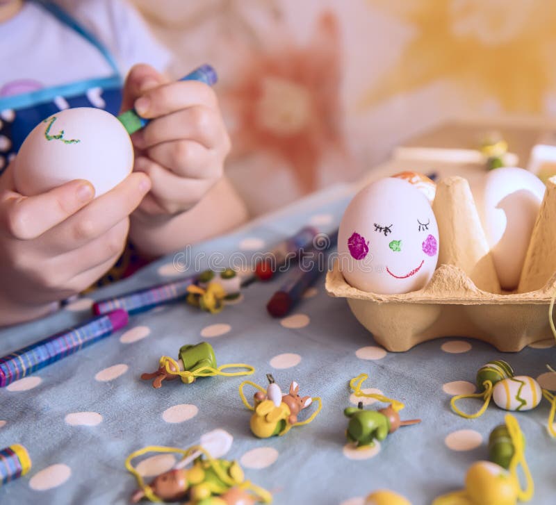 Kind-` s Griffe verzieren Eier für Ostern lizenzfreies stockbild Kind-` s Griffe verzieren Eier für Ostern lizenzfreies stockbild