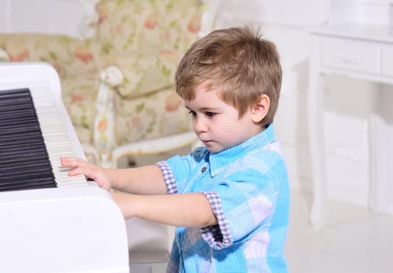 Kind sitzen nahe Klaviertastatur, wei?er Hintergrund Kind wenden Freizeit nahe Musikinstrument auf Der nette und entzückende Jung stockfotografie Kind sitzen nahe Klaviertastatur, wei?er Hintergrund Kind wenden Freizeit nahe Musikinstrument auf Der nette und entzückende Jung stockfotografie