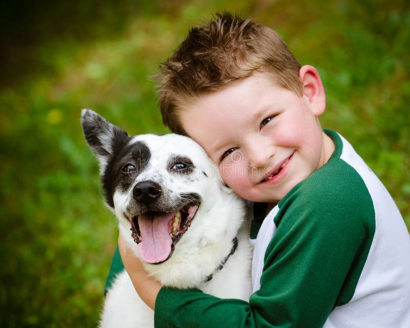 Kind umfasst liebevoll seinen Schoßhund lizenzfreie stockbilder Kind umfasst liebevoll seinen Schoßhund lizenzfreie stockbilder