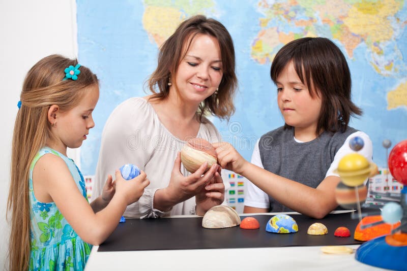 Kinder in der grundlegenden Wissenschaftsklasse studieren unseren Solarsystemfokus O stockbild Kinder in der grundlegenden Wissenschaftsklasse studieren unseren Solarsystemfokus O stockbild