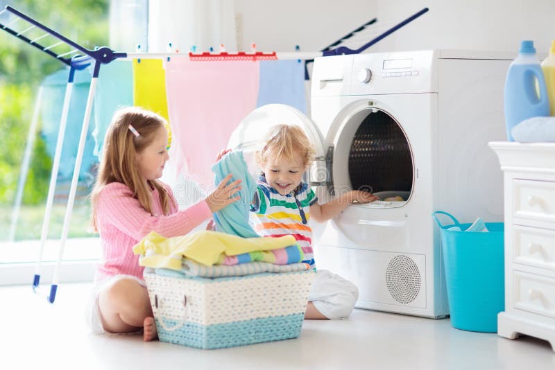 Kinder in der Waschküche mit Waschmaschine lizenzfreie stockfotografie