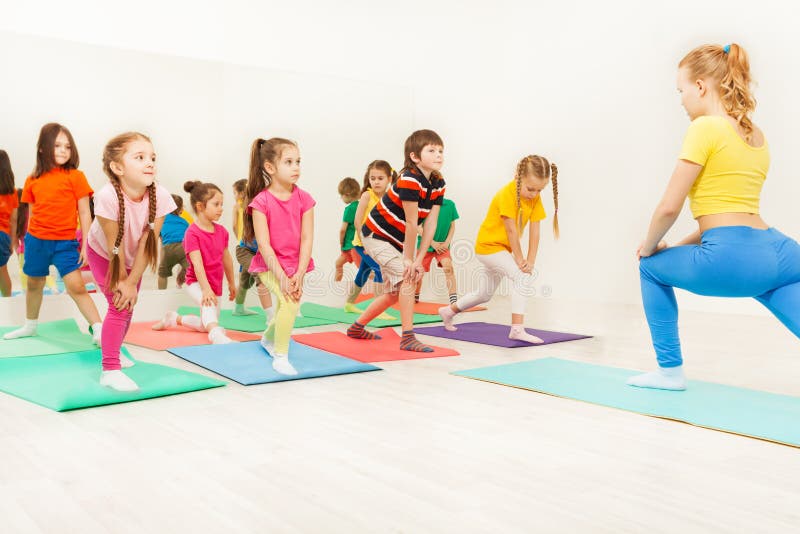 Kinder, die gymnastische Übungen in der Eignungsklasse tun