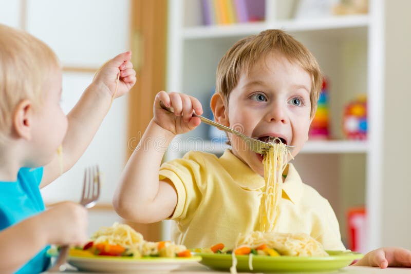 Kinder, die im Kindergarten essen stockbild Kinder, die im Kindergarten essen stockbild