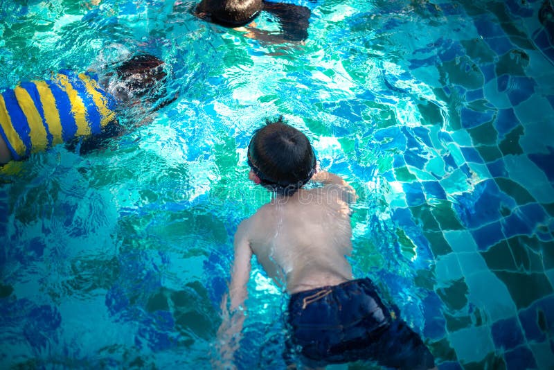 Kinder, die im Pool schwimmen lizenzfreie stockbilder Kinder, die im Pool schwimmen lizenzfreie stockbilder