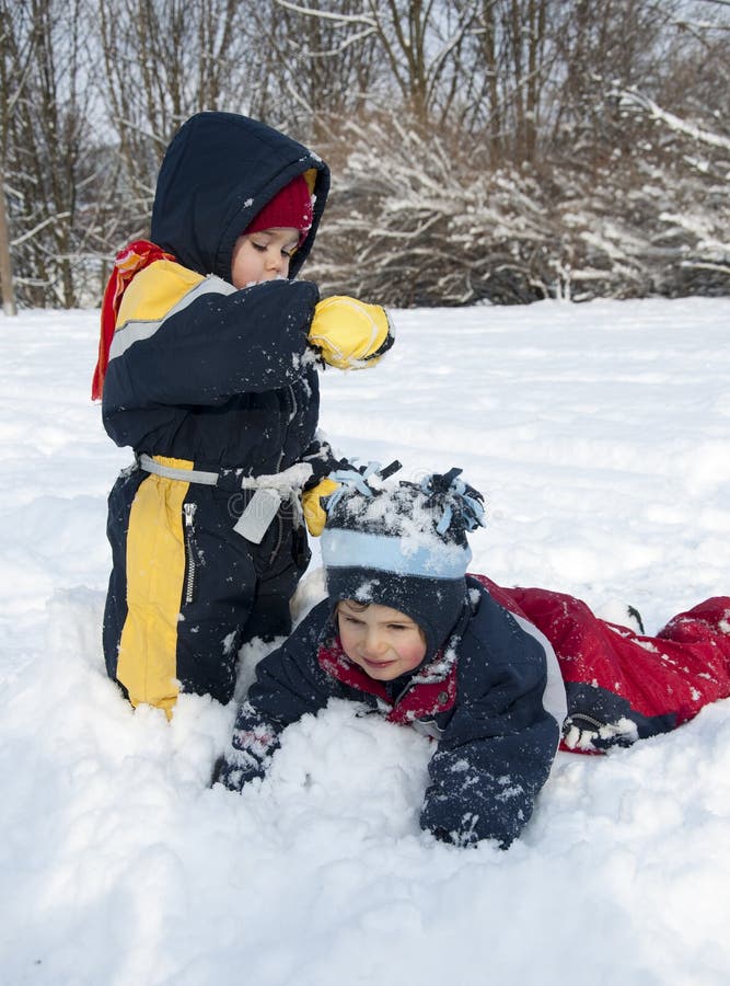 Kinder, die im Schnee spielen lizenzfreie stockbilder Kinder, die im Schnee spielen lizenzfreie stockbilder