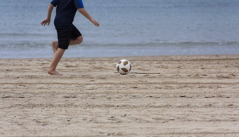 Kinder, die mit einem Ball auf dem Strand spielen lizenzfreie stockbilder Kinder, die mit einem Ball auf dem Strand spielen lizenzfreie stockbilder