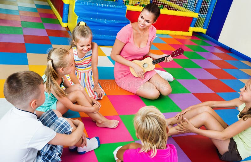 Kinder, die mit Lehrer sitzen und Musik in der Klasse hören stockfotos Kinder, die mit Lehrer sitzen und Musik in der Klasse hören stockfotos