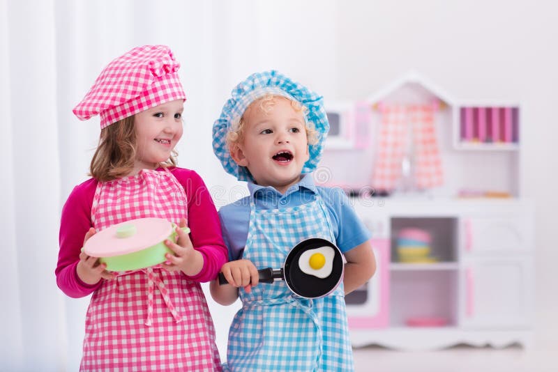 Kinder, die mit Spielzeugküche spielen stockbilder Kinder, die mit Spielzeugküche spielen stockbilder