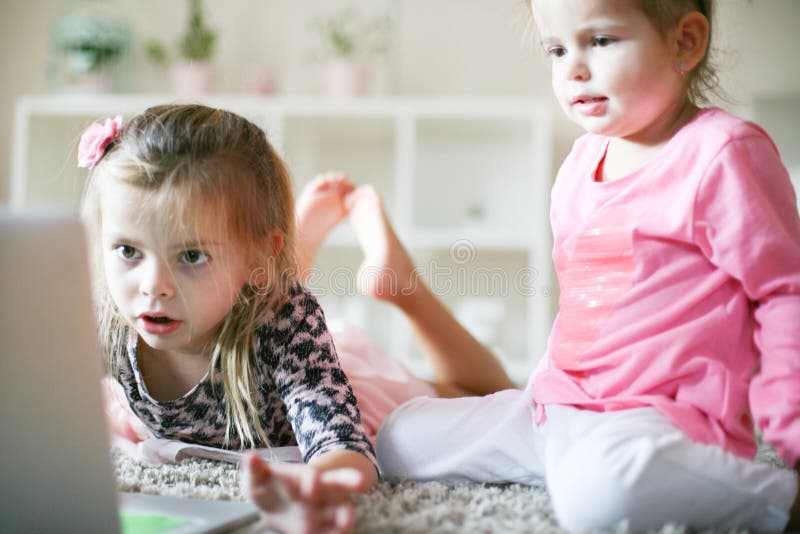 Kinder, die zusammen Laptop zu Hause verwenden lizenzfreie stockbilder Kinder, die zusammen Laptop zu Hause verwenden lizenzfreie stockbilder