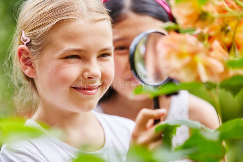 Children explore nature in garden using loupe with curiosity. Children explore nature in garden using loupe with curiosity