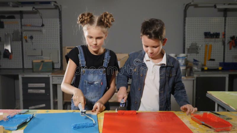Kinder malen mit Bürsten Im Handwerksbetrieb Schule-gealterte Kinder, die Spaß zusammen malen und haben bearbeiten lack stock video