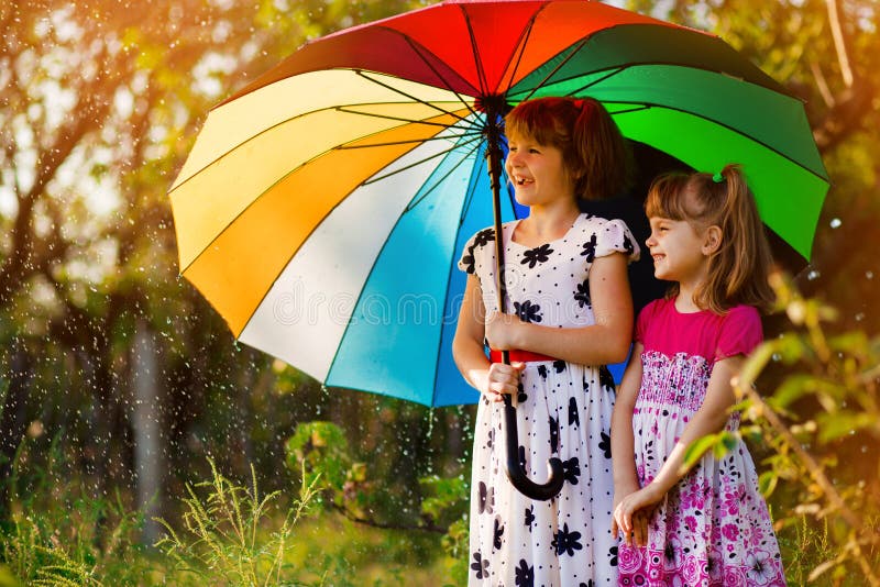 Kinder mit dem bunten Regenschirm, der im Herbstduschregen spielt Wenig M?dchen spielen im Park durch regnerisches Wetter lizenzfreies stockfoto Kinder mit dem bunten Regenschirm, der im Herbstduschregen spielt Wenig M?dchen spielen im Park durch regnerisches Wetter lizenzfreies stockfoto