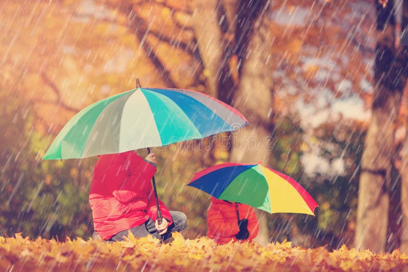 Kinder mit Regenschirmen im schönen Herbsttag lizenzfreie stockfotos