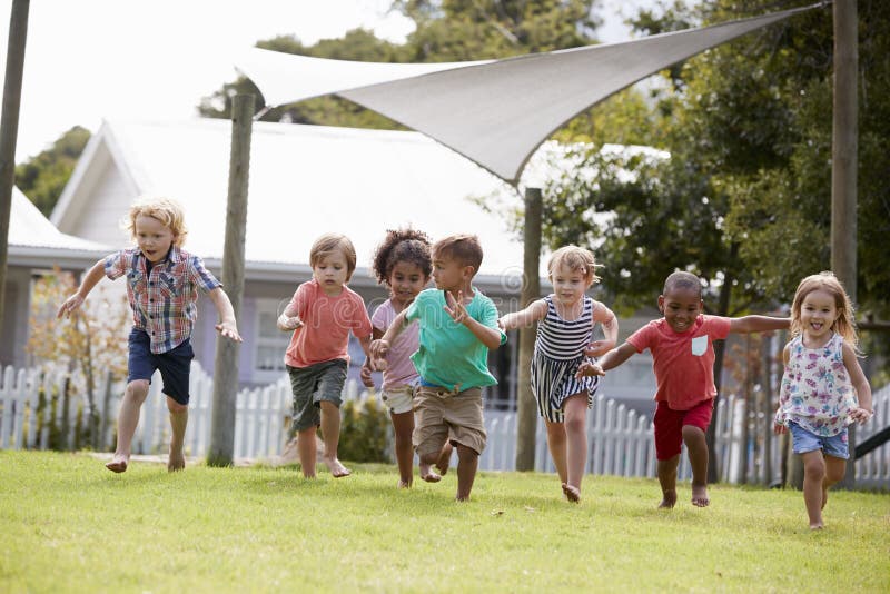 Kinder an Montessori-Schule, die Spaß draußen während des Bruches hat