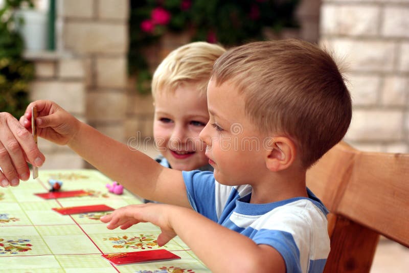 Kinder spielen ein Tabellenspiel lizenzfreie stockfotografie Kinder spielen ein Tabellenspiel lizenzfreie stockfotografie