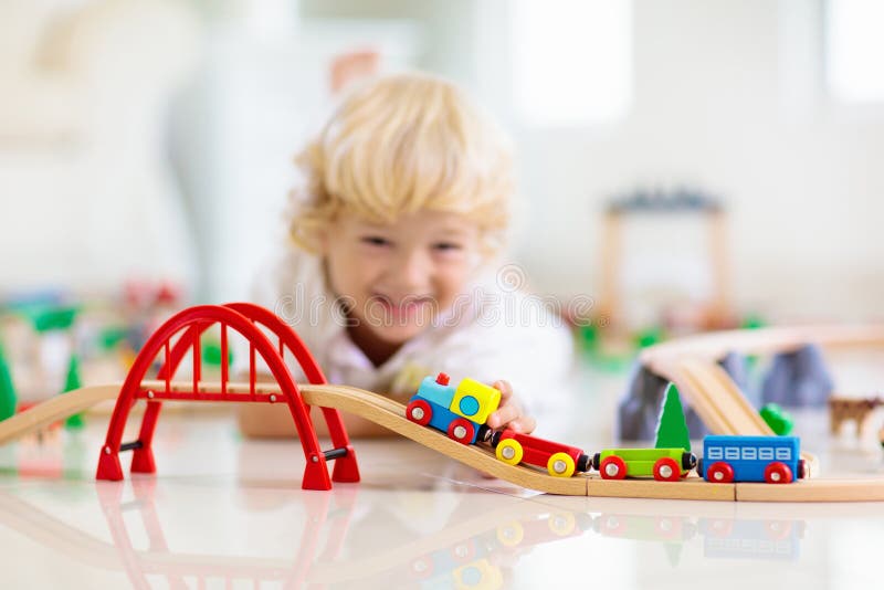 Kinder spielen hölzerne Eisenbahn Kind mit Spielzeugzug lizenzfreie stockbilder Kinder spielen hölzerne Eisenbahn Kind mit Spielzeugzug lizenzfreie stockbilder