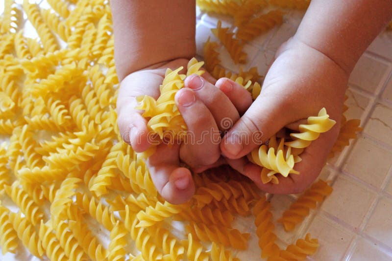 Little baby touches the palm of the pasta. Little baby touches the palm of the pasta.