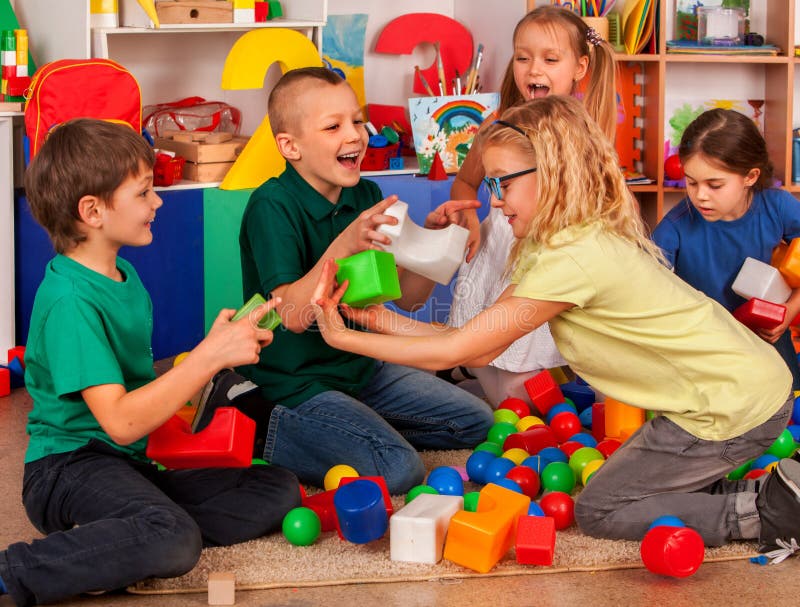 Kinderbausteine im Kindergarten Gruppenkinder, die Spielzeugboden spielen lizenzfreie stockfotos Kinderbausteine im Kindergarten Gruppenkinder, die Spielzeugboden spielen lizenzfreie stockfotos