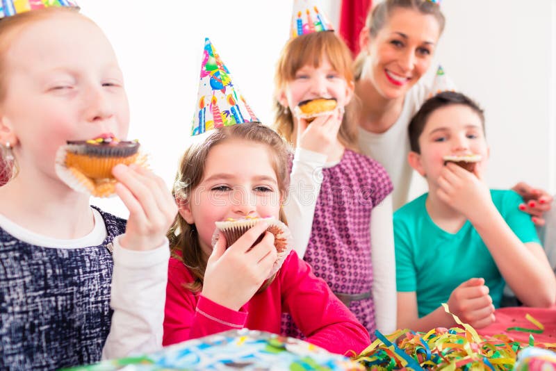 Kinderen bij verjaardagspartij met muffins en cake stock foto's Kinderen bij verjaardagspartij met muffins en cake stock foto's