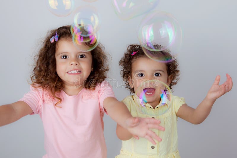 Excited happy kids children little girls playing with bubbles. Excited happy kids children little girls playing with bubbles