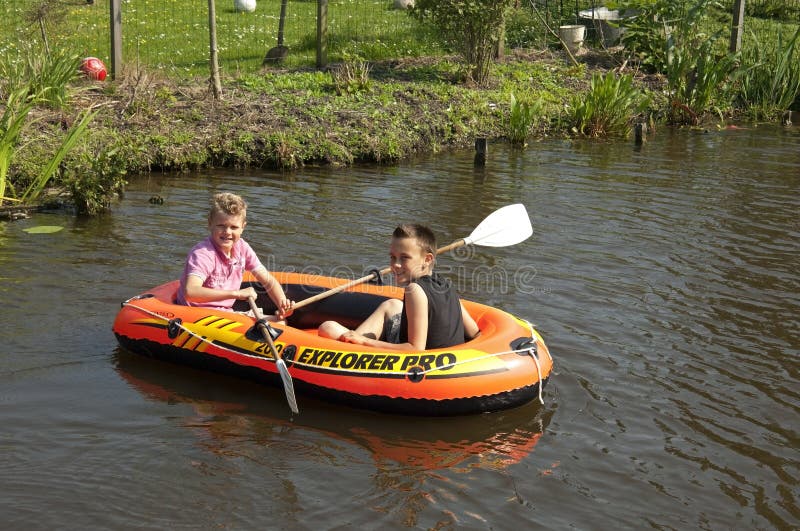 Group portrait of two boys, rowing their boat on the small river the Vlist, enjoying the beautiful weather and their holidays. Netherlands, South Holland province, region, area Krimpenerwaard, city, small town Schoonhoven: On the water of the river Vlist sailing, boating two boys, friends in the water. The vlist is in the summer mainly a tourist attraction, a recreational area for walkers, cyclists and boaters. Group portrait of two boys, rowing their boat on the small river the Vlist, enjoying the beautiful weather and their holidays. Netherlands, South Holland province, region, area Krimpenerwaard, city, small town Schoonhoven: On the water of the river Vlist sailing, boating two boys, friends in the water. The vlist is in the summer mainly a tourist attraction, a recreational area for walkers, cyclists and boaters.