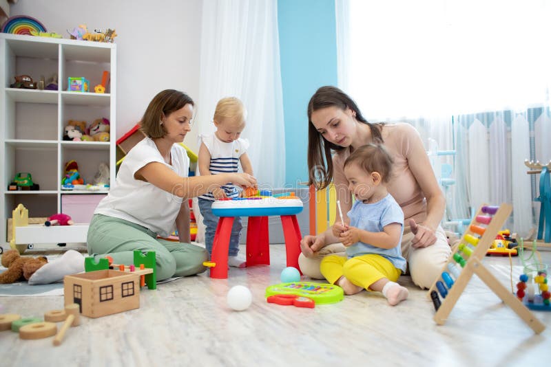 Kinderen die op de vloer spelen met educatief speelgoed Speelgoed voor kleuterschool en kleuterschool Kinderen in kleuterscholen stock foto's Kinderen die op de vloer spelen met educatief speelgoed Speelgoed voor kleuterschool en kleuterschool Kinderen in kleuterscholen stock foto's